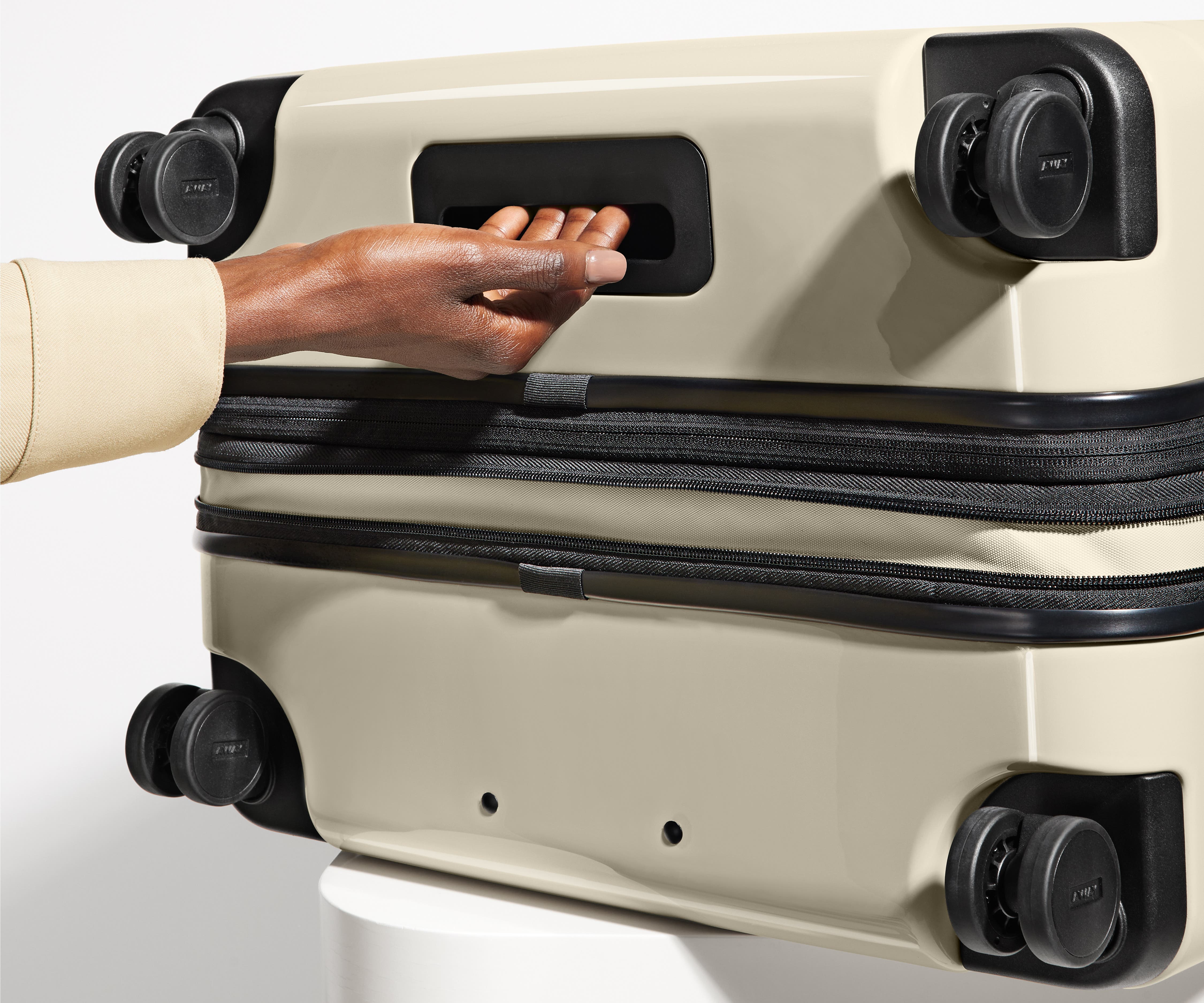 The Medium Flex suitcase in Salt White (Gloss) shown from below highlighting the underside grab handle