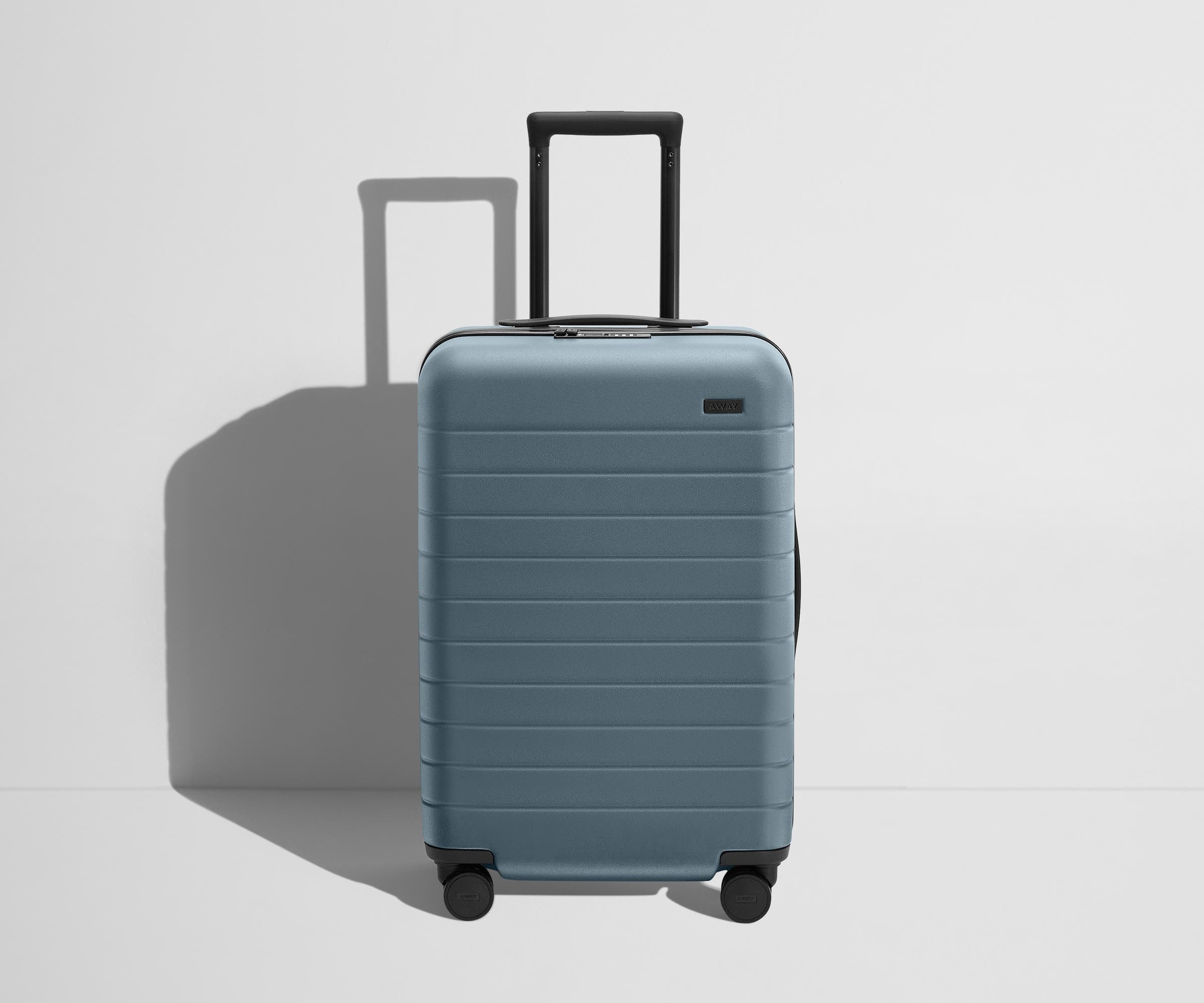 Front product view of The Bigger Carry-On Flex suitcase in Coast Blue with raised handle