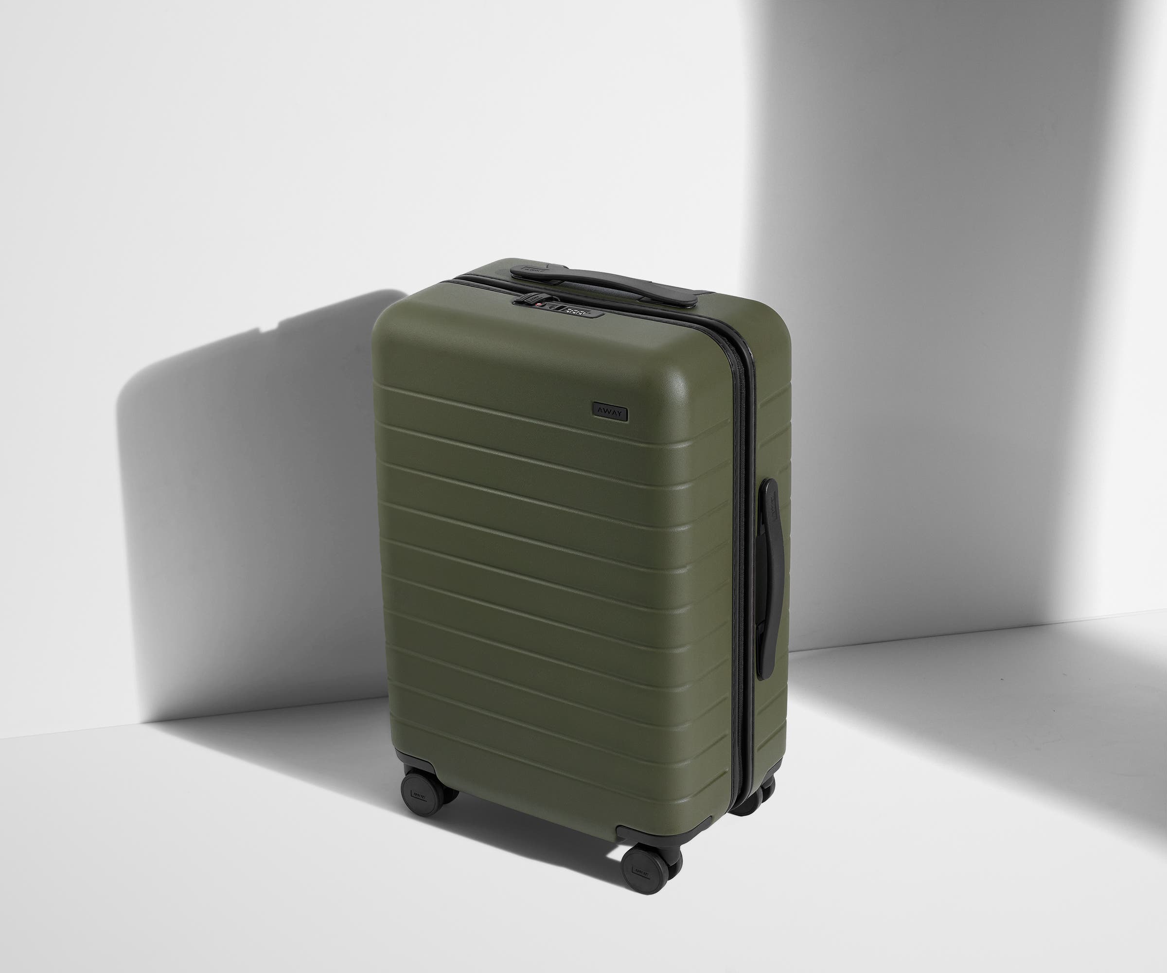 Angled product view of The Bigger Carry-On suitcase in Olive Green