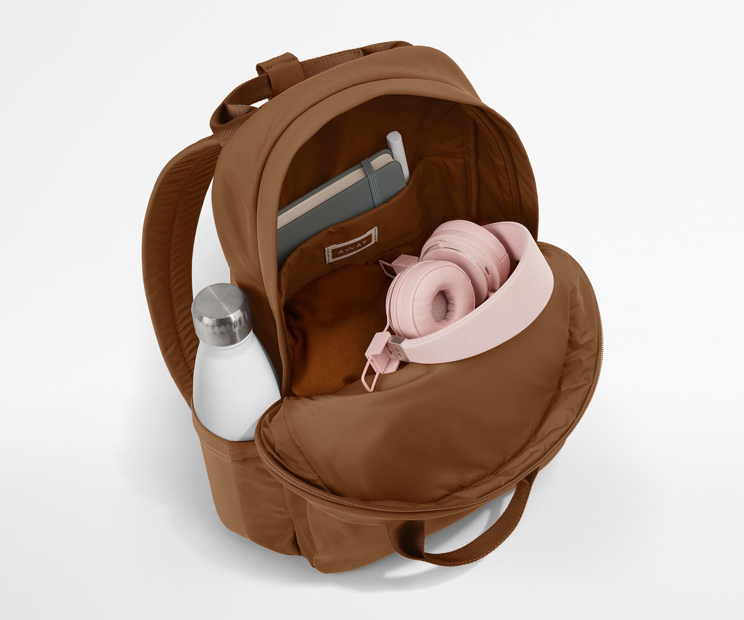 Featherlight Backpack packed with a sweater, notebook, headphones, and water bottle