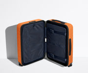 The Bigger Carry-On suitcase in Sorbet Orange shown open in an upright position to show interior organization and compression system