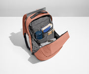Main compartment of the Everywhere Zip Backpack packed with a book, water bottle, notebooks, light layer of clothing, and a key attached to the interior key leash. A laptop is packed in the exterior laptop pocket.