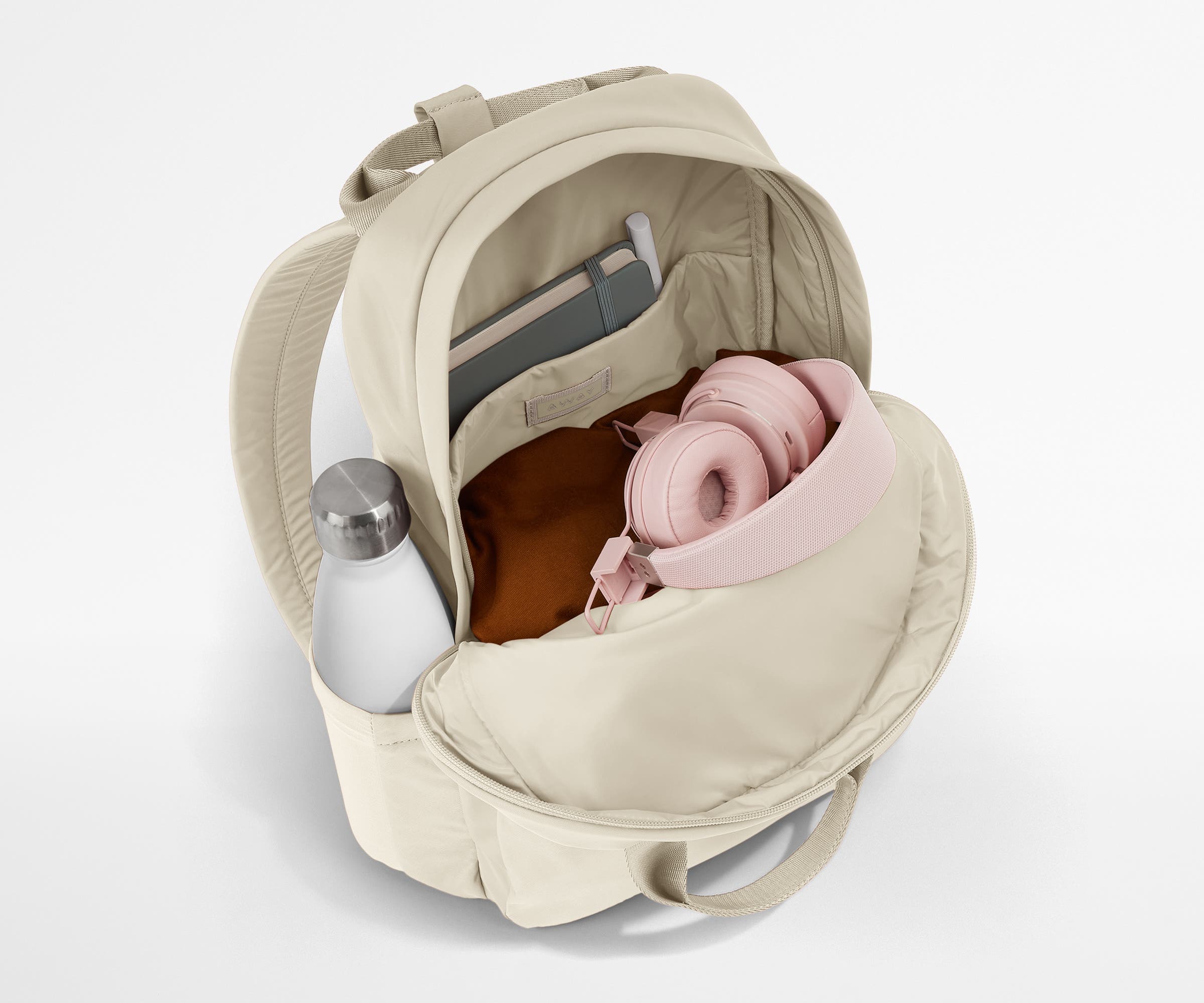 Featherlight Backpack packed with a sweater, notebook, headphones, and water bottle