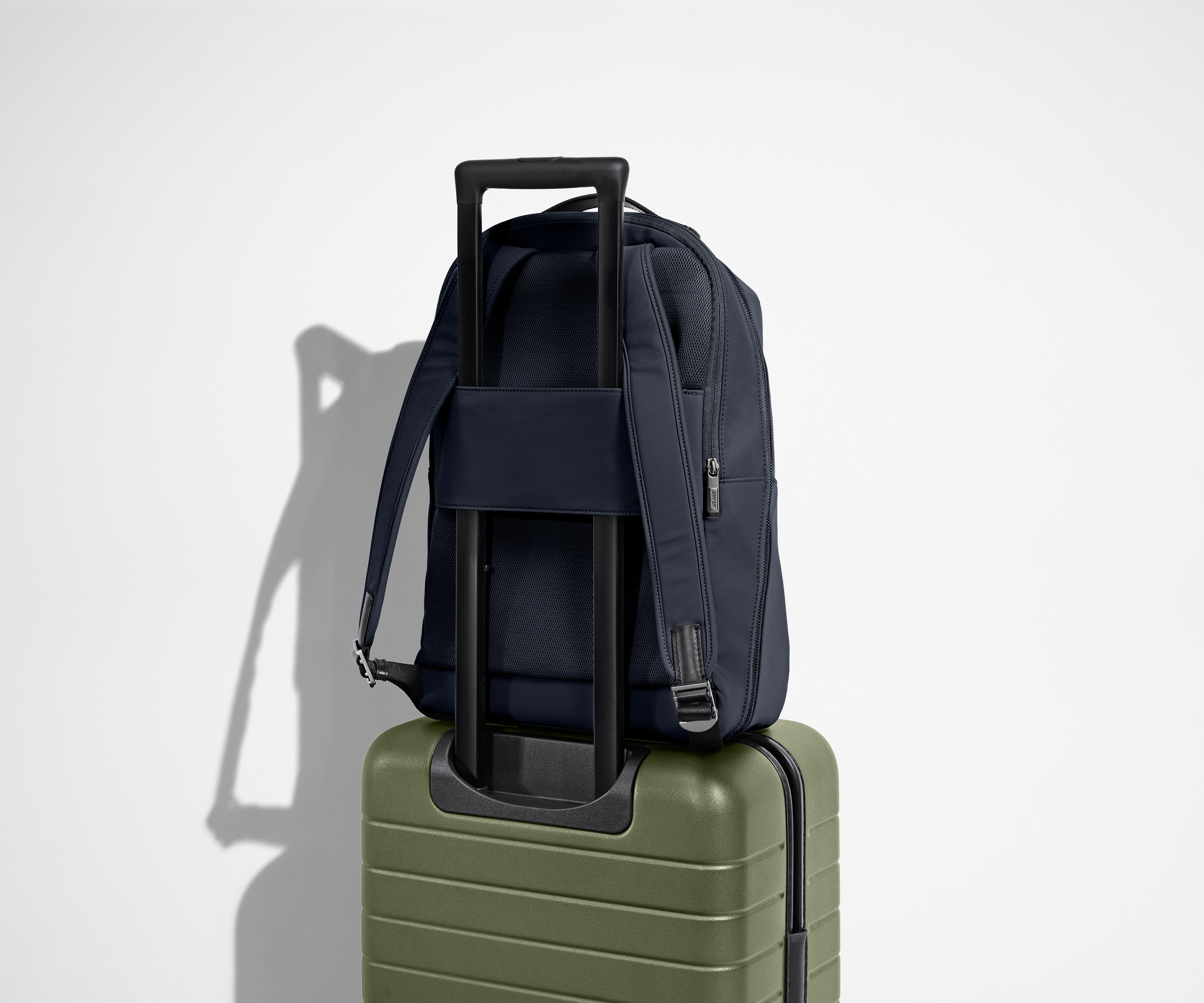Navy Everywhere Zip Backpack on top of the Away suitcase