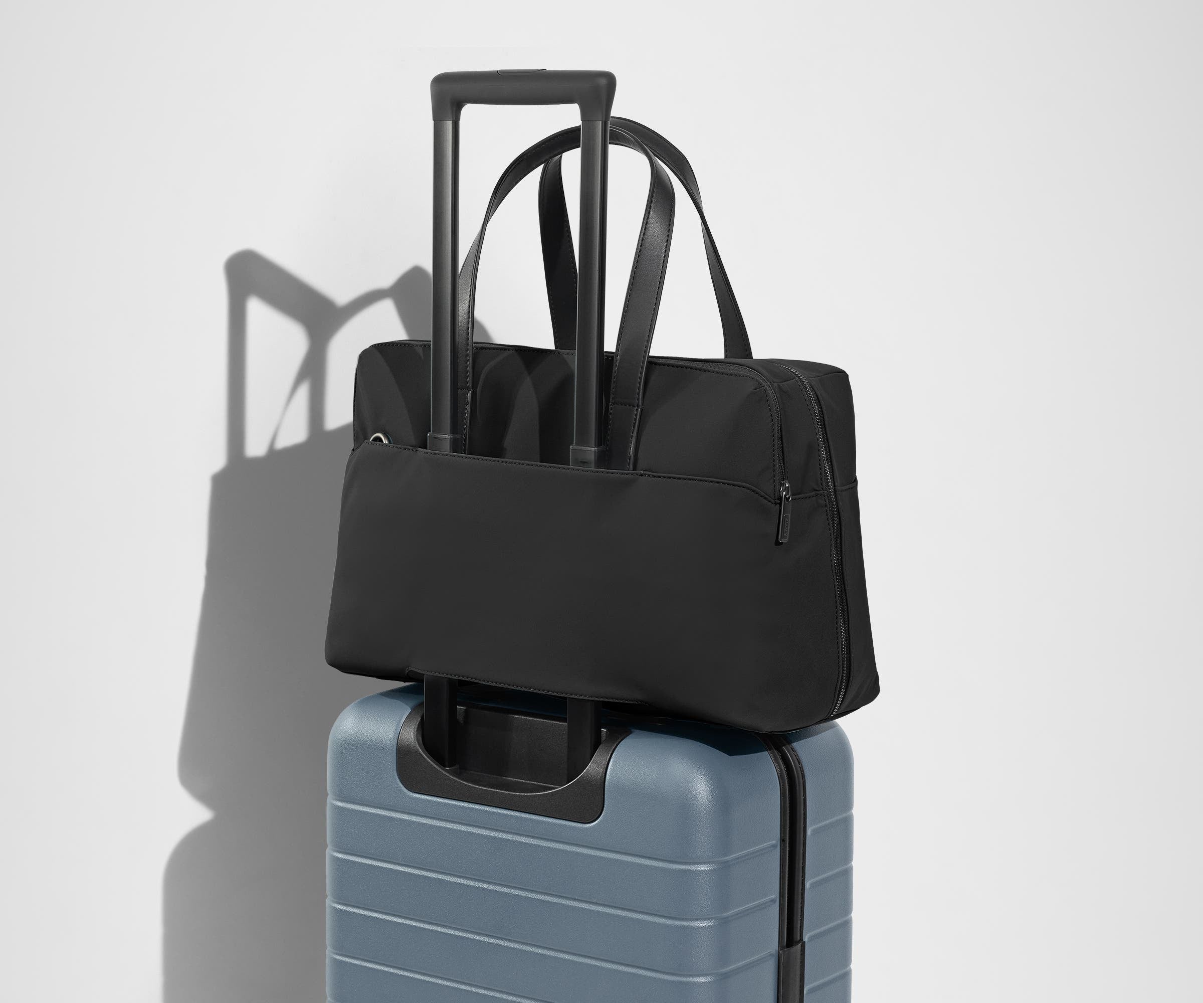 The Everywhere Bag secured to an Away suitcase by its trolley sleeve
// Our Everywhere Bags are designed with a trolley sleeve that slides onto your suitcase to keep it in place while you’re on the move. Paired with The Bigger Carry-On. 