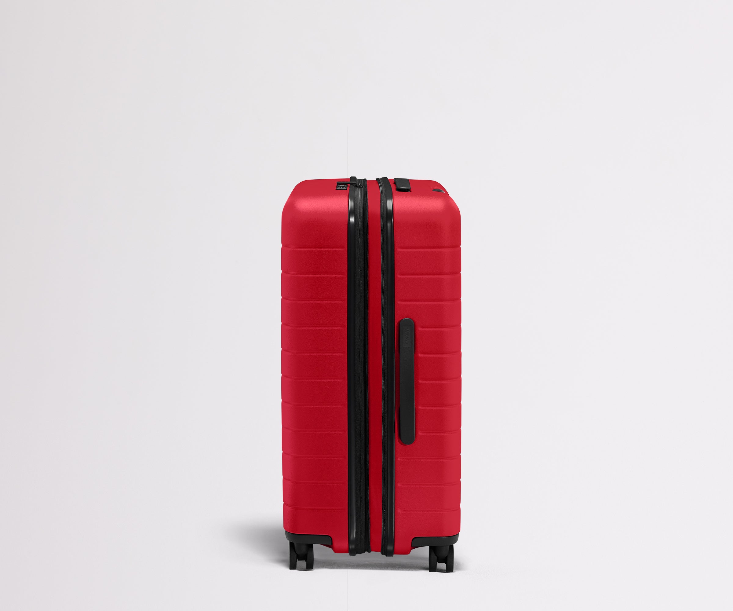 Red suitcase with black handle and wheels on a light gray background
