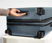 The Medium Flex suitcase in Coast Blue shown from below highlighting the underside grab handle