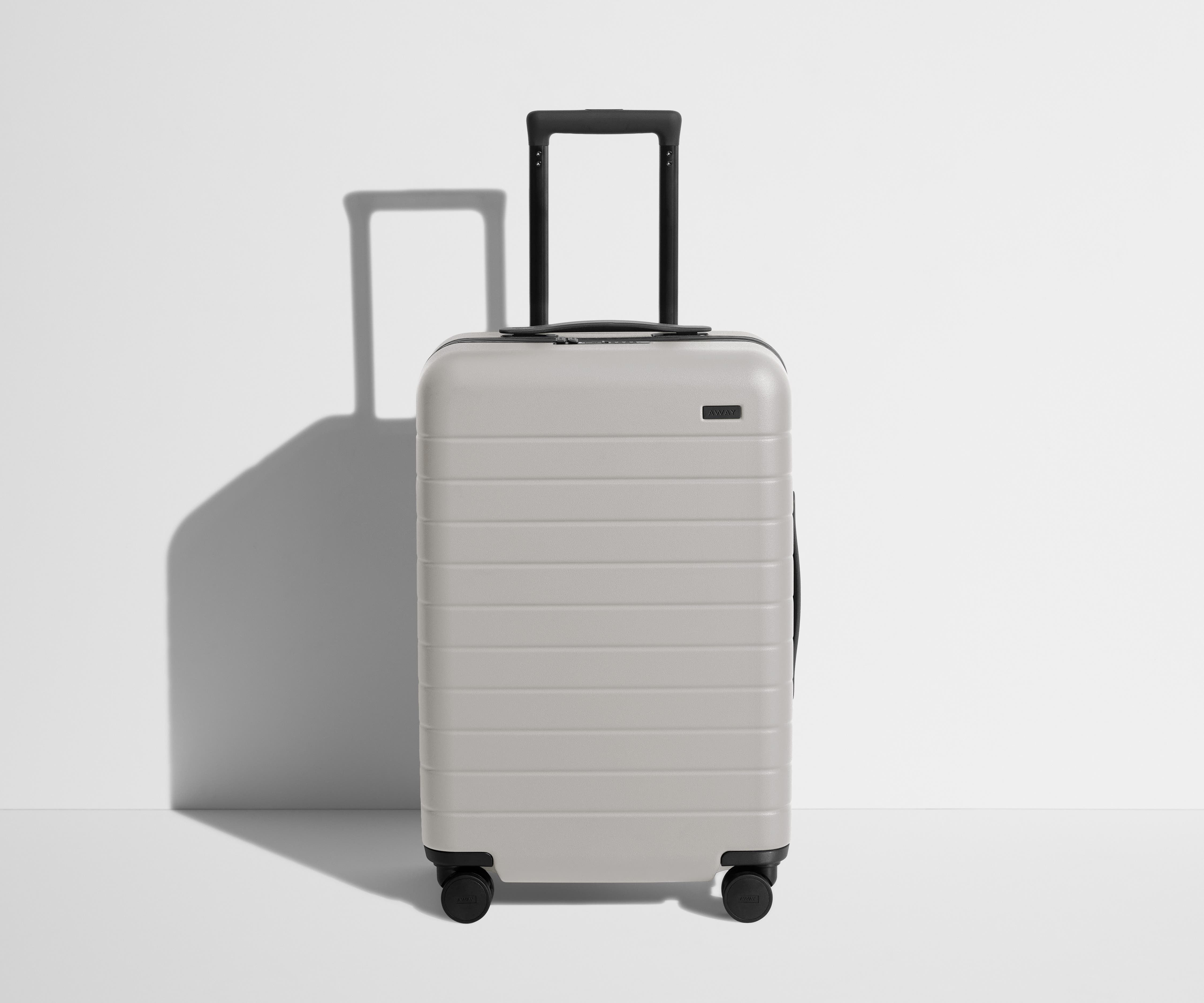 Front product view of The Bigger Carry-On suitcase in Cloud Gray with raised handle